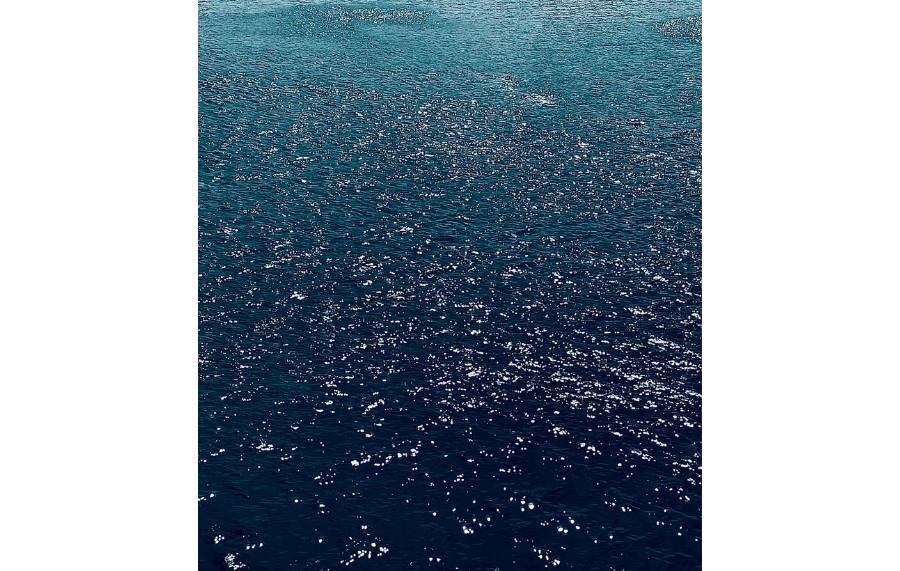 Water-a close-up aerial view of sparkling blue ocean water with sunlight reflecting off the surface, creating bright highlights".